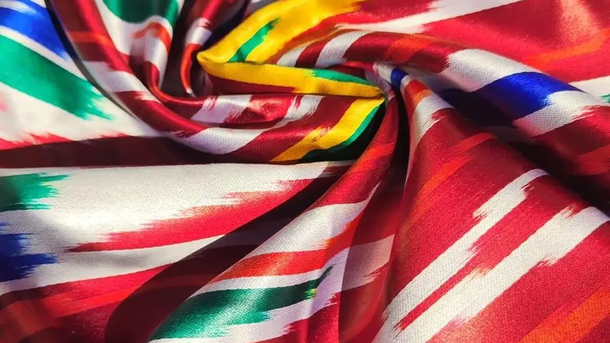 Rot-weiß gemusterte Ikat-Seide in weichen Wellen drapiert